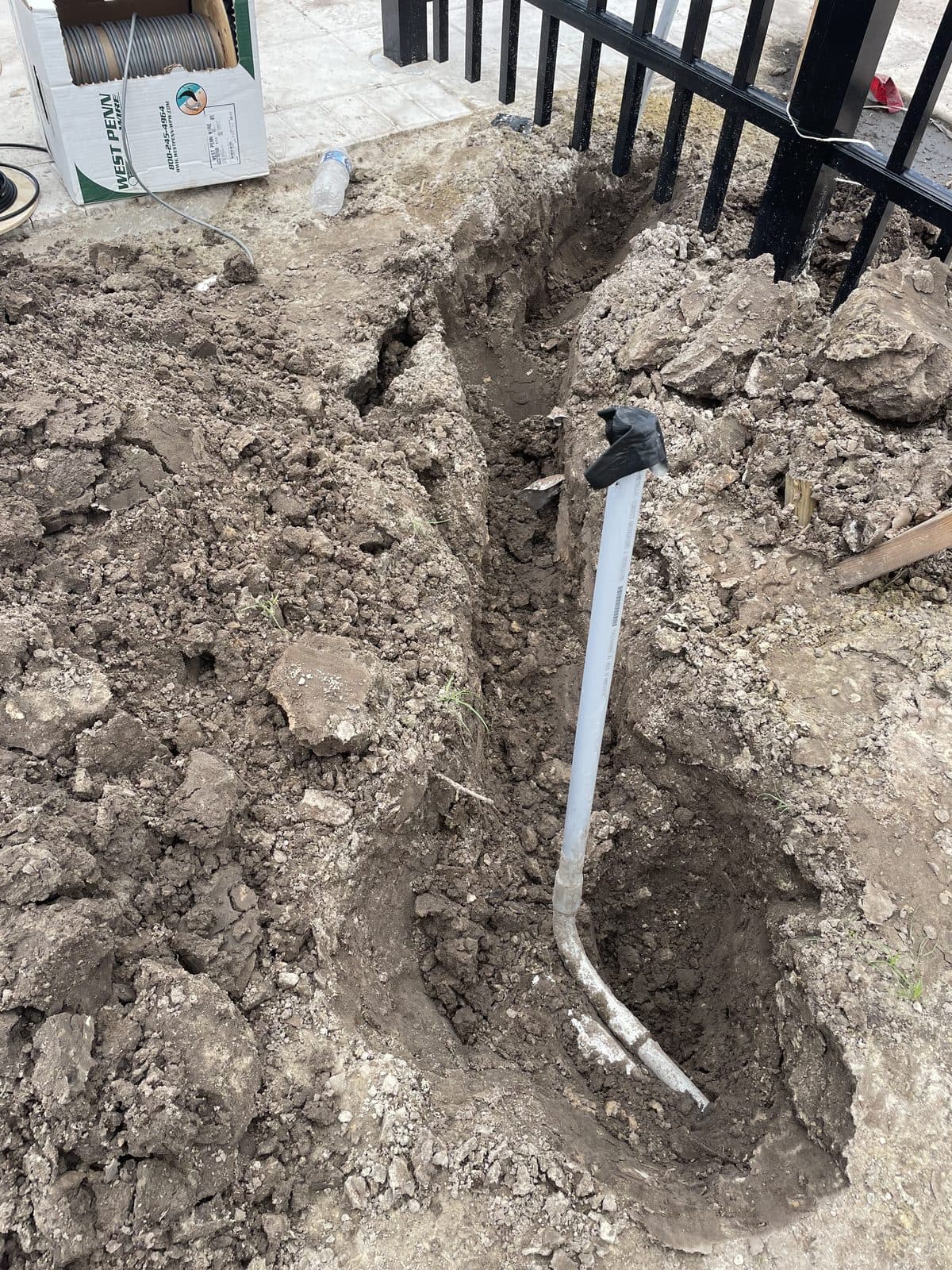 Conduit trenched in along a property fence line